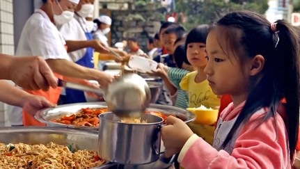 Young children in line receiving food