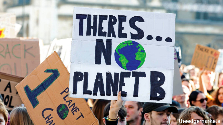 Protestors hold placard that reads 