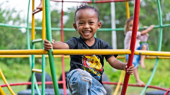 Young child playing in playground with friend