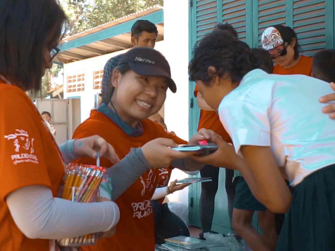 PRUVolunteers hand out supplies to children.